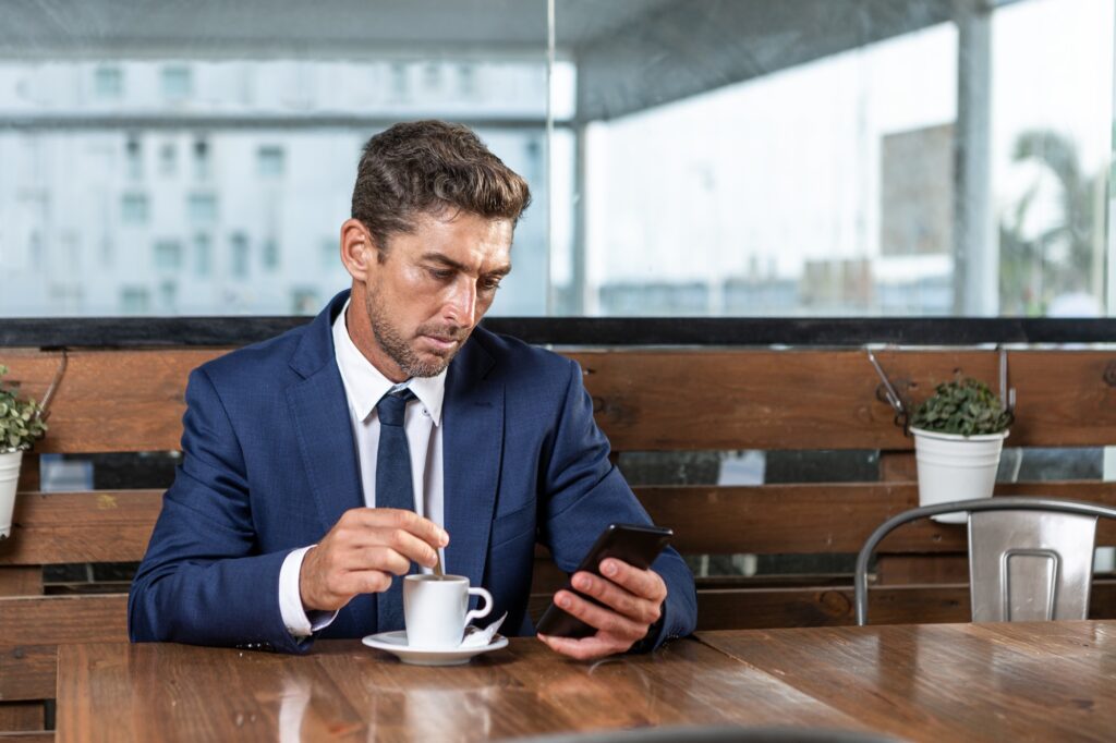Businessman using smartphone in cafe